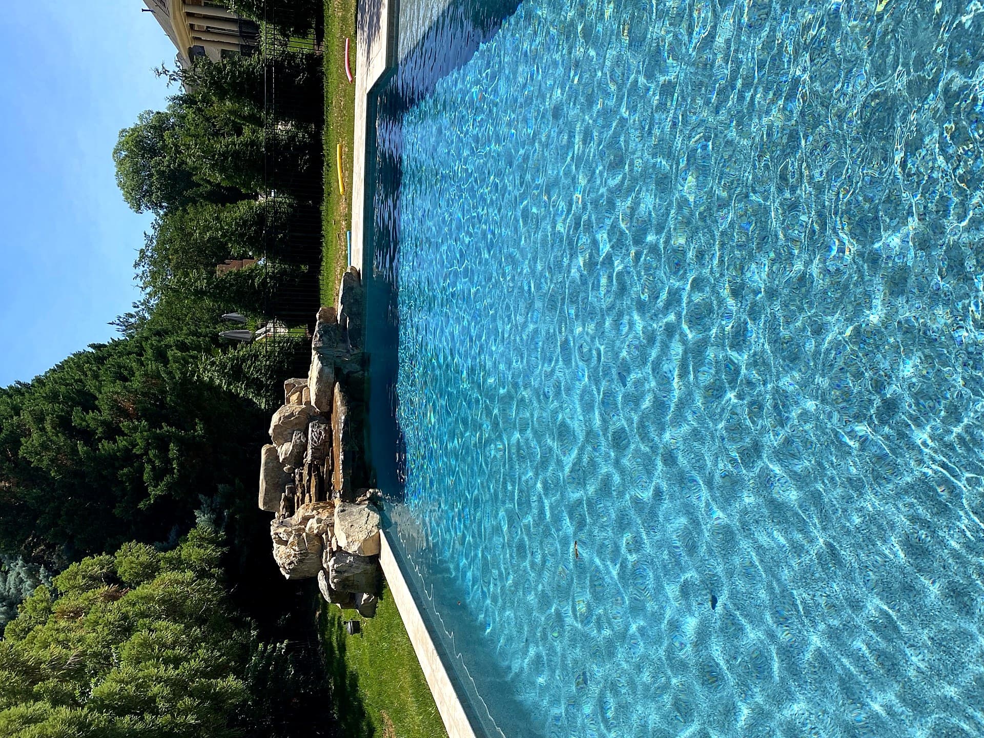 Boulder waterfall pool with lush landscaping